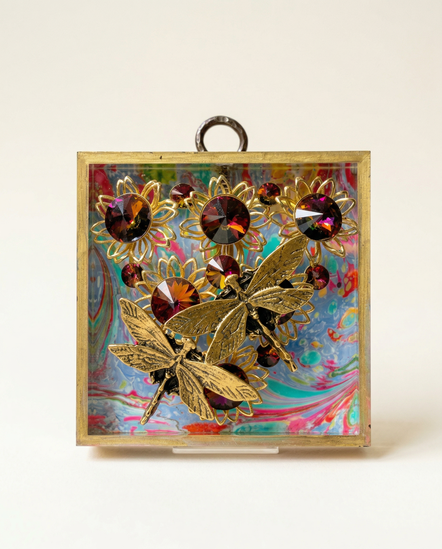 Decorative dragonflies on vintage jewelry and colorful gemstones on a marbled acrylic frame art 