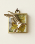 Brass wall art of a bird in flight on a textured background