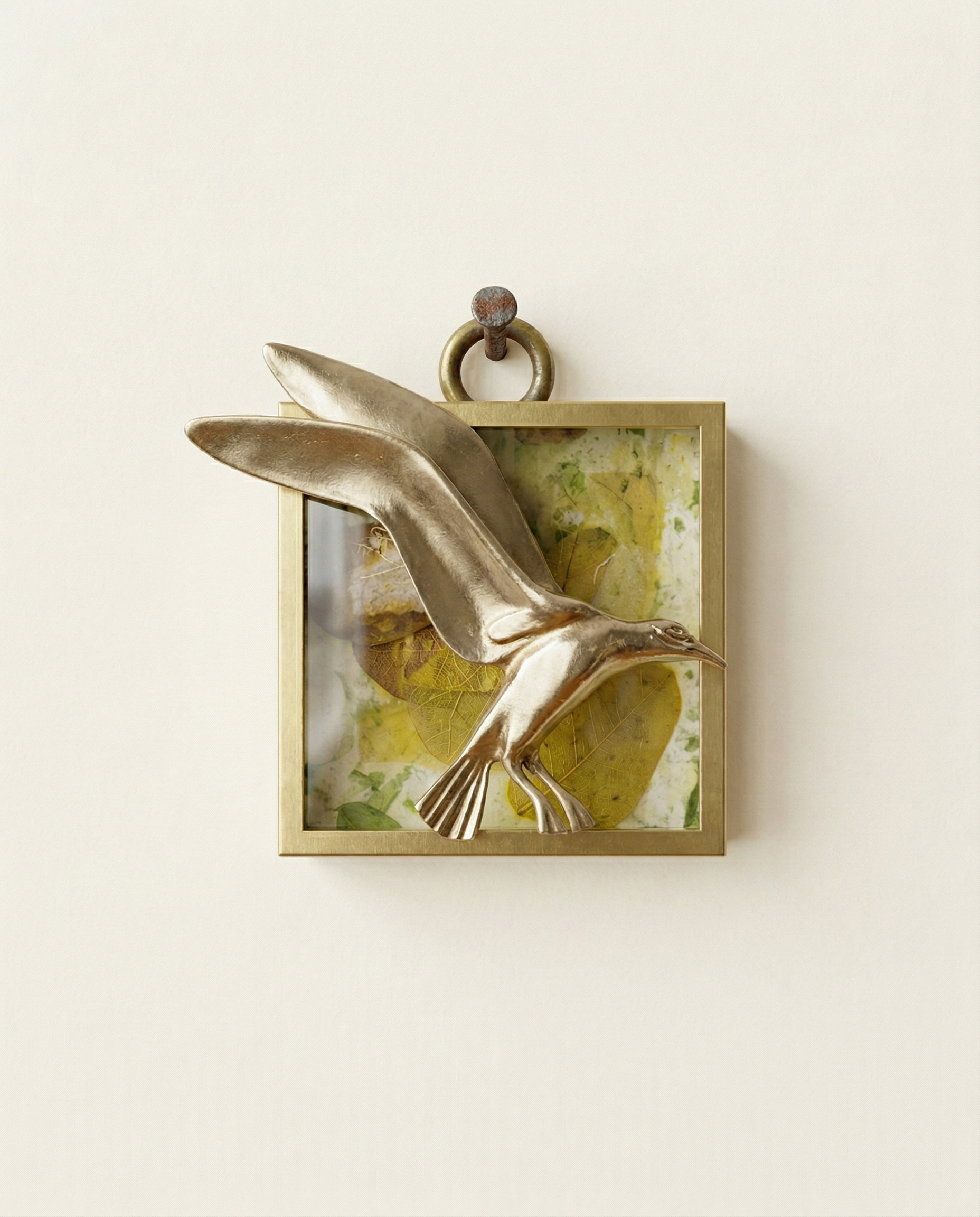 Brass wall art of a bird in flight on a textured background