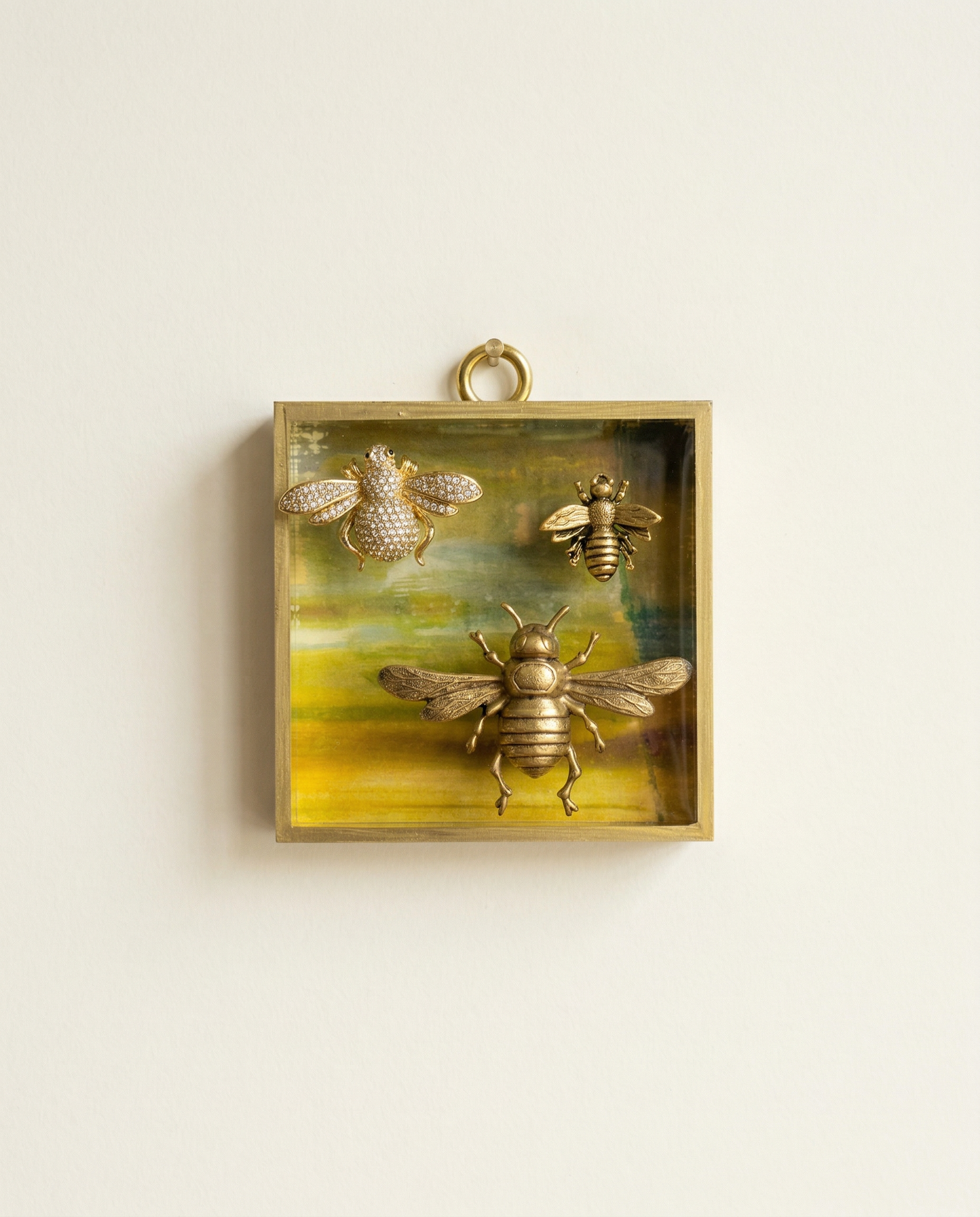 Decorative wall art with bee designs in a gold frame on a beige background