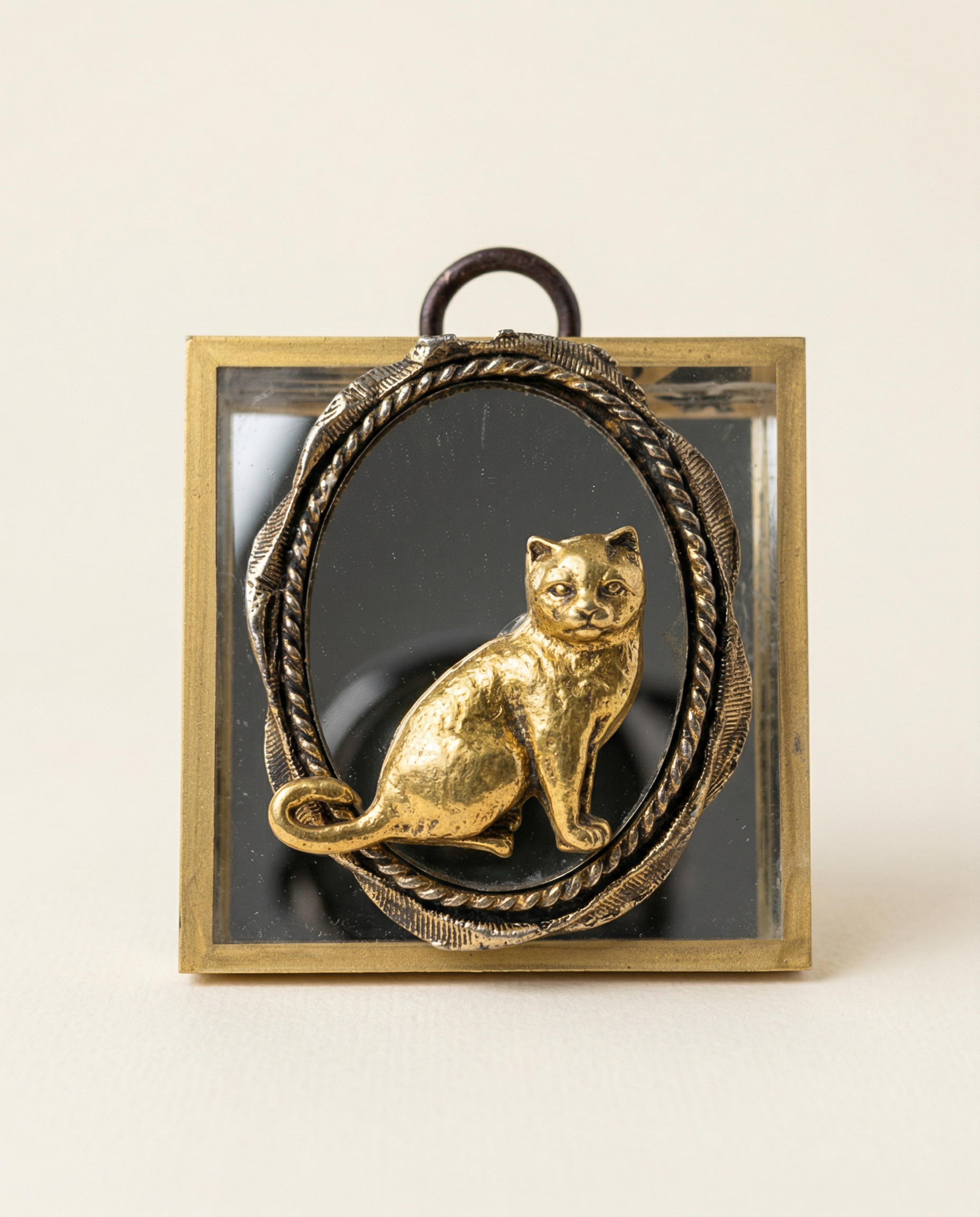 Decorative wall art with a gold cat figure on a black background, framed in bronze.