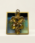 Gold cross pendant with floral design on a marbled acrylic frame art 