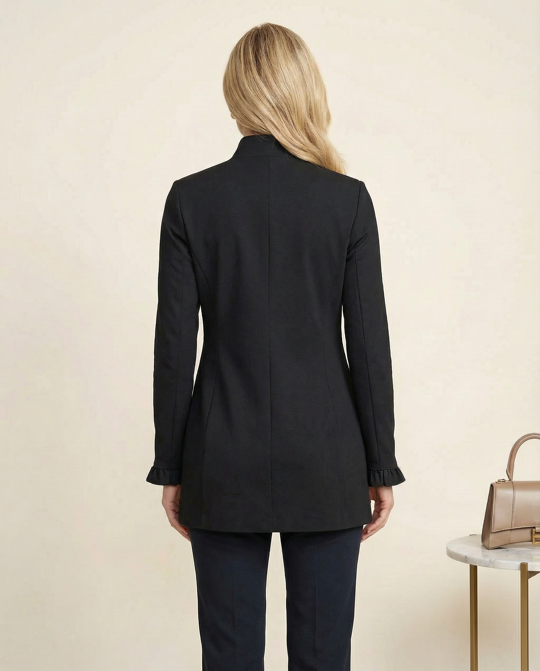woman in black jacket with ruffle sleeves