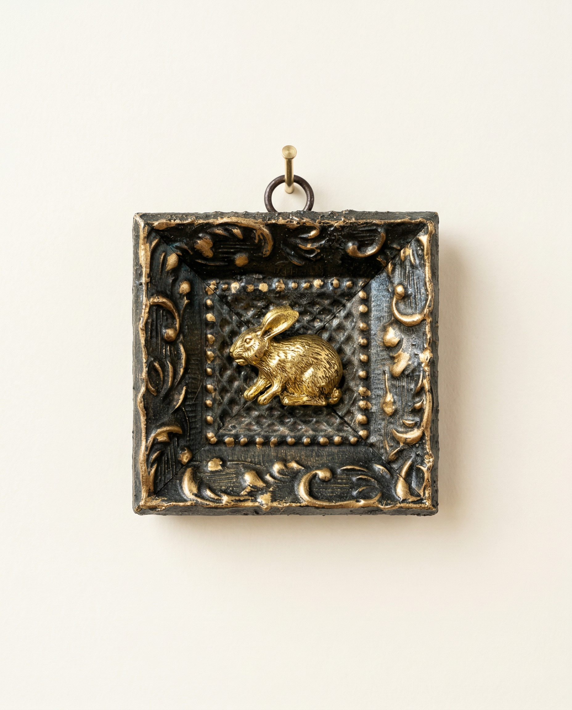 gold rabbit pendant on a brown painted frame  art 