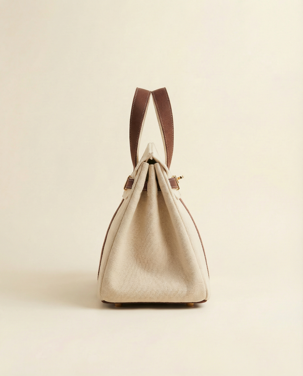 Beige handbag with brown handles on a beige background