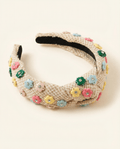 Beige headband with colorful floral embellishments on a white background