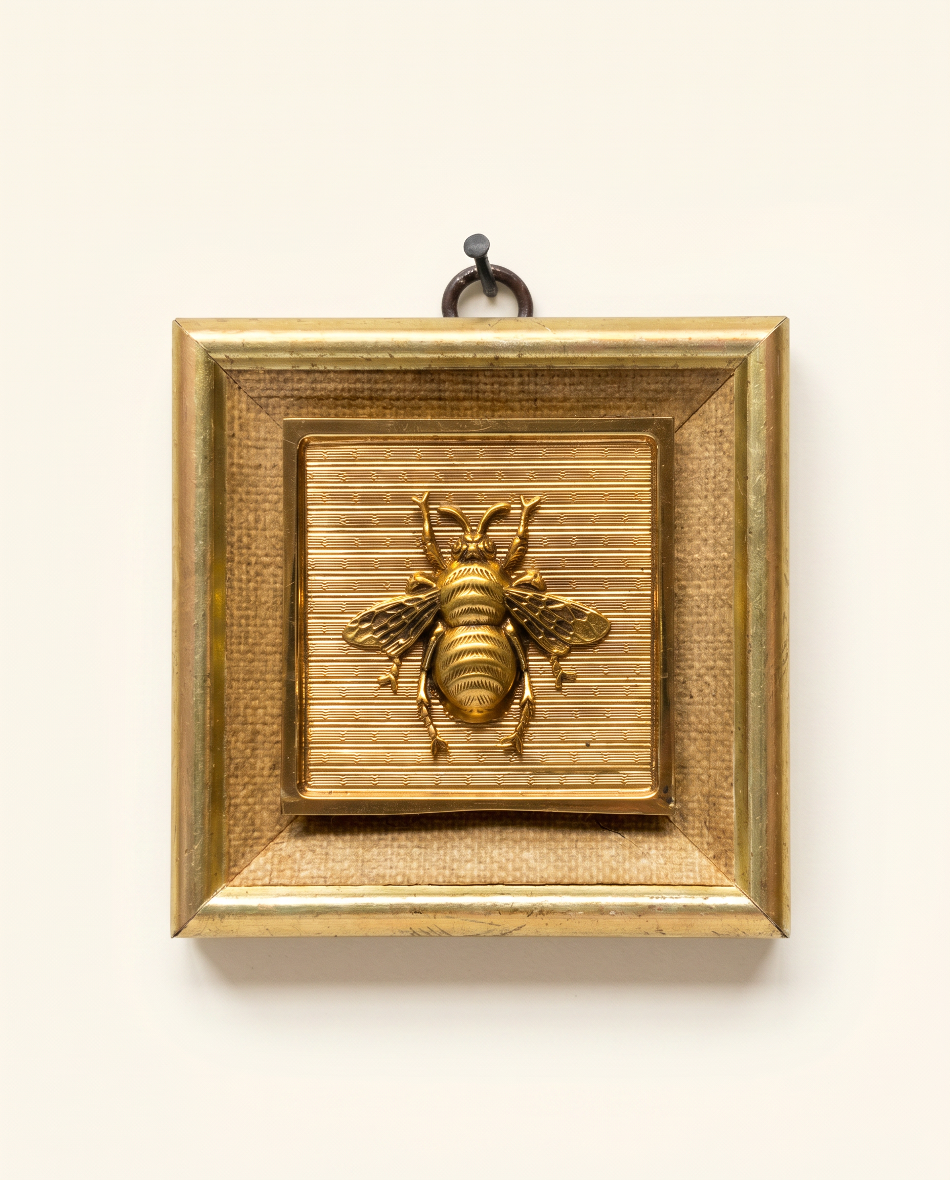 Decorative wall art with a gold frame with gold bee and fabric inlay on a wooden frame art