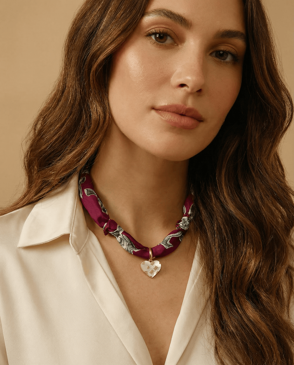 Woman wearing a scarf necklace against a beige background