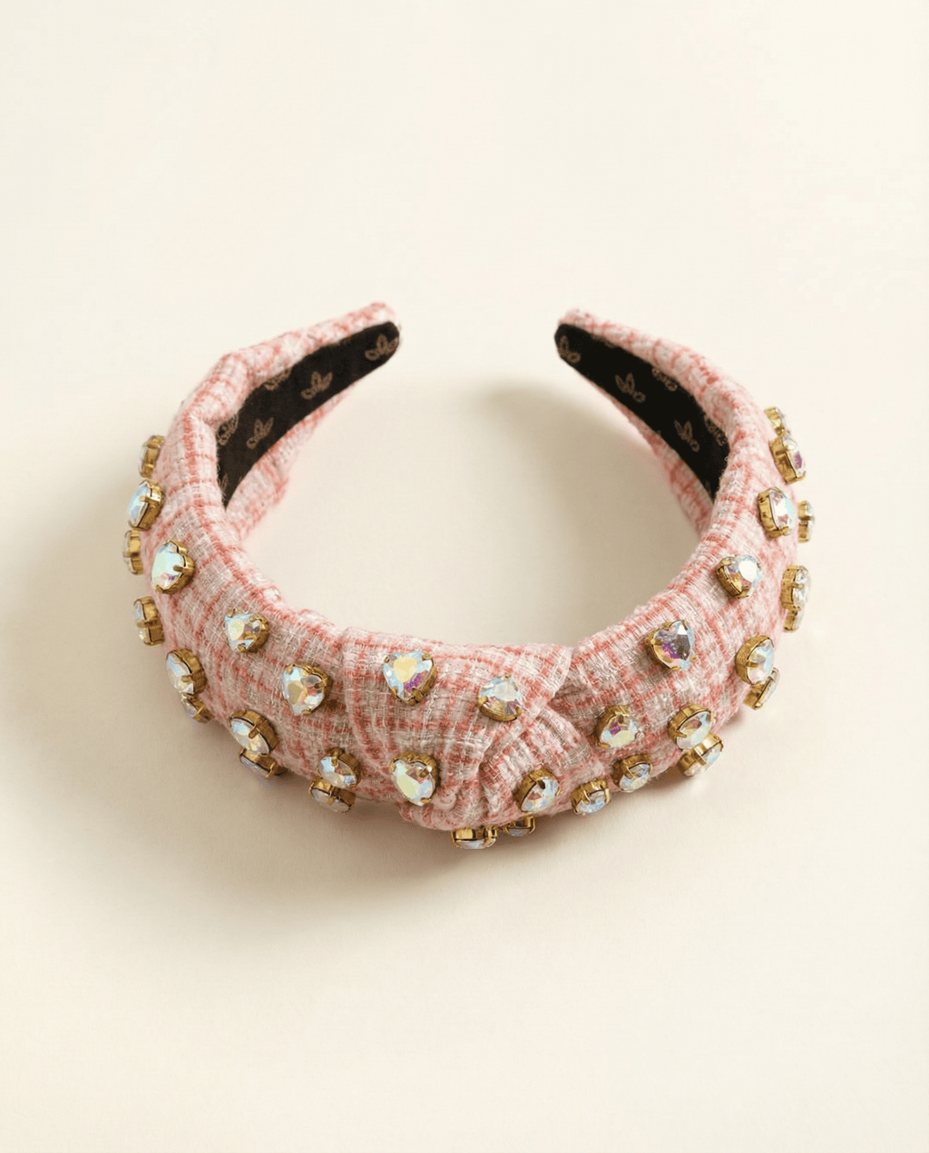 Pink headband with embellishments on a beige background