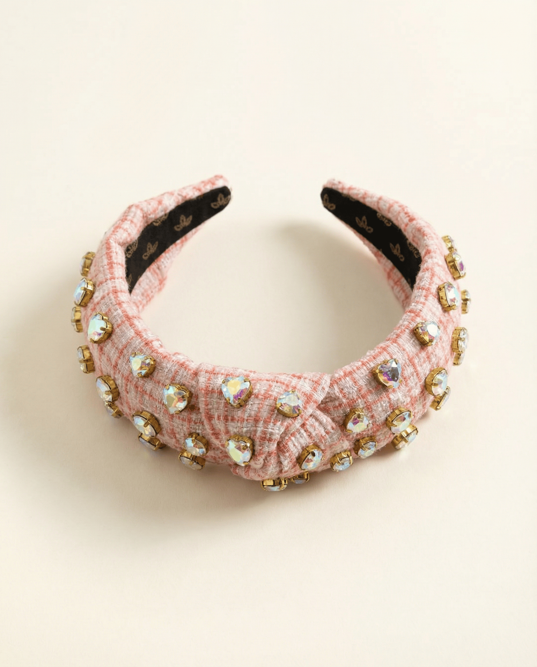 Pink headband with embellishments on a beige background
