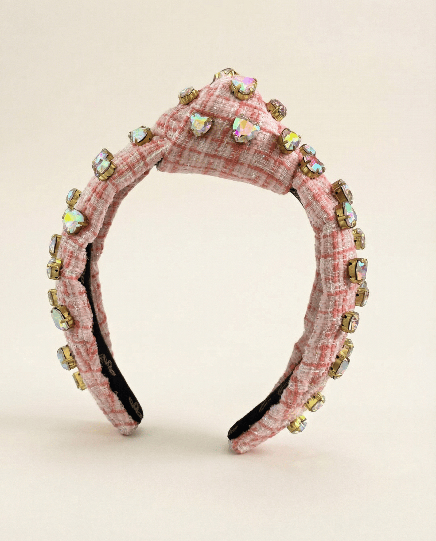 Pink plaid headband with embellishments on a beige background