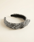 Patterned headband with a knot on a beige background