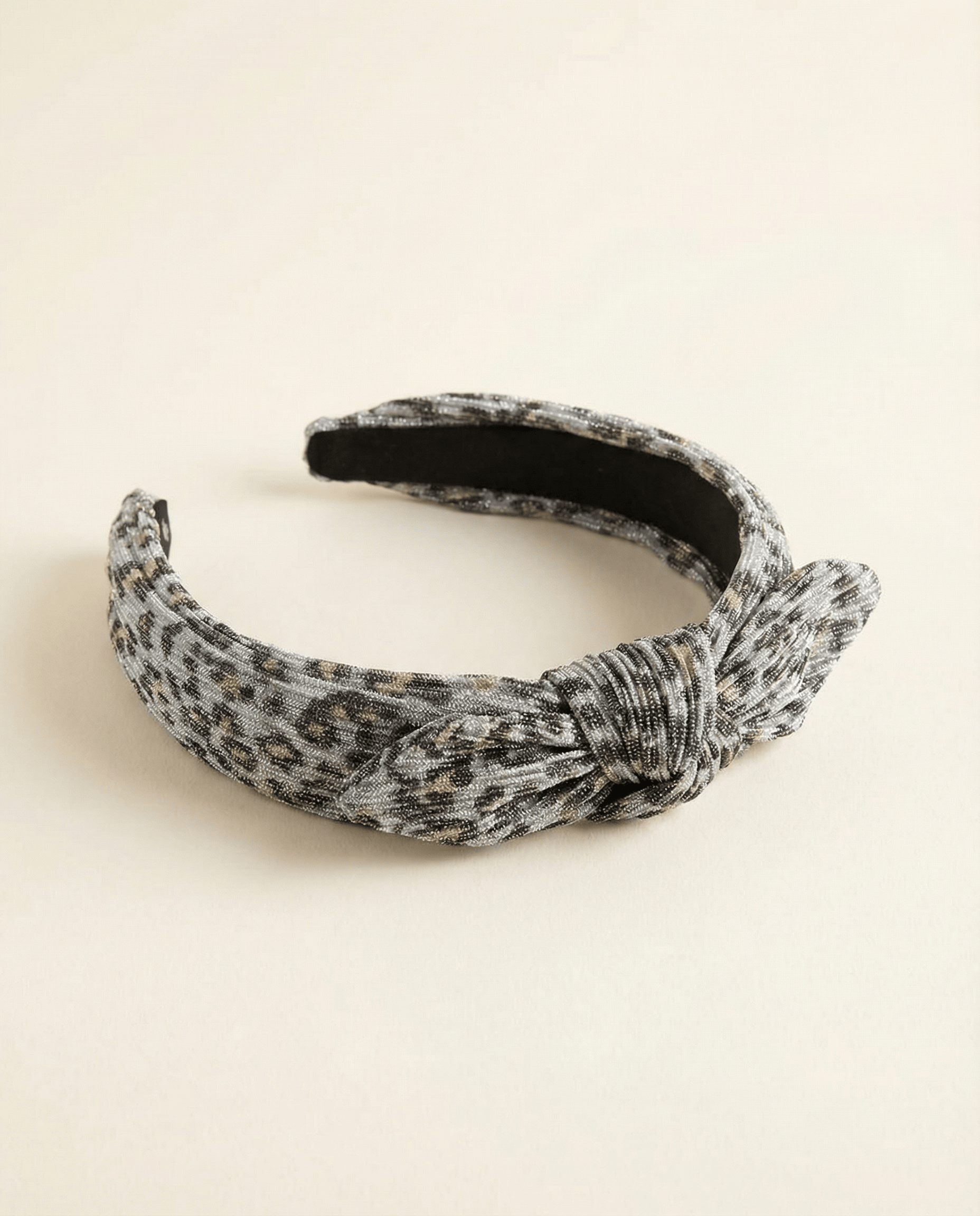Patterned headband with a knot on a beige background